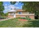 View of the front yard with healthy lawn, flowerbed, and home exterior at 4591 S Pennsylvania St, Englewood, CO 80113