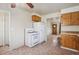 Functional kitchen with wooden cabinets and white appliances near the living area at 4591 S Pennsylvania St, Englewood, CO 80113