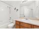 Traditional bathroom featuring a shower-tub combo, white tile, and a wood vanity at 2430 S Halifax Way, Aurora, CO 80013