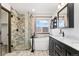 Modern bathroom featuring a glass shower, soaking tub, dark vanity, and stylish fixtures at 2430 S Halifax Way, Aurora, CO 80013