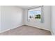A bright, carpeted bedroom with a large window letting in natural light at 2430 S Halifax Way, Aurora, CO 80013