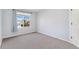 A bright, carpeted bedroom with a large window letting in natural light at 2430 S Halifax Way, Aurora, CO 80013