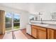 Well-lit kitchen with sliding glass doors to a patio area, sink, and wood cabinetry at 2430 S Halifax Way, Aurora, CO 80013