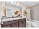 Stylish bathroom with a tub-shower combo, decorative mirror, and a neutral color palette at 631 Felicity Loop, Castle Rock, CO 80109