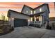 Charming two-story home with a gray garage door, inviting front porch, and a warm sunset backdrop at 631 Felicity Loop, Castle Rock, CO 80109