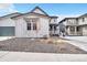 Exterior view of a modern home with a gray facade, a two-car garage, and a gravel front yard at 631 Felicity Loop, Castle Rock, CO 80109