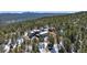 Stunning aerial view of a modern home nestled in the woods with mountain views at 2536 N State Highway 67, Sedalia, CO 80135