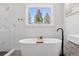 Bright bathroom featuring a freestanding soaking tub with modern fixtures and natural light at 2536 N State Highway 67, Sedalia, CO 80135