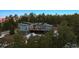 Exterior view of the modern home surrounded by towering pines and snow covered ground at 2536 N State Highway 67, Sedalia, CO 80135