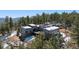 Stunning exterior view of a modern residence nestled among snow-dusted trees and lush landscaping at 2536 N State Highway 67, Sedalia, CO 80135