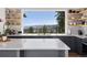 Bright kitchen with shaker cabinets, open shelves, and large window showing beautiful mountain view at 2536 N State Highway 67, Sedalia, CO 80135