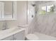 Beautiful bathroom featuring new shower with tiled walls and grey vanity at 4624 W Virginia Ave, Denver, CO 80219