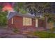 Classic brick home with large window providing ample natural light, showcasing a tranquil evening scene at 4624 W Virginia Ave, Denver, CO 80219