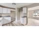 Bright kitchen features modern white cabinets, grey countertops, and light wood-look flooring at 4624 W Virginia Ave, Denver, CO 80219