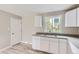 Updated kitchen with white cabinetry, a stainless steel sink, and a view of the backyard at 4624 W Virginia Ave, Denver, CO 80219