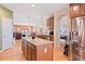 Gourmet kitchen island with granite countertops, hardwood floors, and stainless steel refrigerator at 8796 E 150Th Ct, Thornton, CO 80602