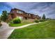 Charming townhouse with a well-maintained lawn and walkway leading to the entrance at 10451 Truckee St # 2D, Commerce City, CO 80022