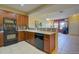 Well-equipped kitchen featuring black appliances and wooden cabinetry with an open floorplan at 10451 Truckee St # 2D, Commerce City, CO 80022