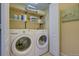 Efficient laundry room featuring a modern washer and dryer, with shelving for storage at 10451 Truckee St # 2D, Commerce City, CO 80022