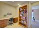 Functional home office with a built-in desk, wooden bookshelf, and a view to the next room at 10451 Truckee St # 2D, Commerce City, CO 80022