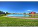 Scenic view of a peaceful pond and lush green lawn in front of a red barn at 10451 Truckee St # 2D, Commerce City, CO 80022