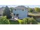 Backyard with large mature trees, patio with furniture, and open lawn area at 7977 Emerson Ave, Frederick, CO 80530