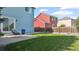 Backyard featuring a concrete patio, gray rocking chair, lush grass, and privacy fence at 7977 Emerson Ave, Frederick, CO 80530