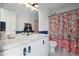 Bright bathroom featuring a white sink vanity, decorated shower curtain, and natural lighting at 7977 Emerson Ave, Frederick, CO 80530
