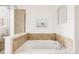 Corner bathtub with tile surround, and a large clear glass shower door at 9852 E Idaho St, Aurora, CO 80247