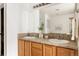 Bathroom with wooden cabinets, double sinks, and a large mirror reflecting natural light at 9852 E Idaho St, Aurora, CO 80247