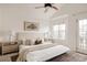 Well-lit bedroom boasts a ceiling fan, neutral decor, and a balcony door for ample natural light at 9852 E Idaho St, Aurora, CO 80247