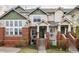 Two-story townhome featuring brick accents, green siding, and a charming front entrance at 9852 E Idaho St, Aurora, CO 80247