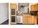 Bright kitchen featuring light wood cabinetry, stainless steel appliances, and pass through window at 9852 E Idaho St, Aurora, CO 80247