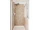 Tiled shower with glass door, overhead shower head, and built-in shelving at 9852 E Idaho St, Aurora, CO 80247