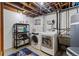 Basement utility area with a washer, dryer, storage shelf, and a window at 4102 W Eastman Ave, Denver, CO 80236