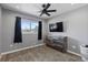 Bedroom with modern fan, gray walls, carpeting, dresser, and view from large window at 4102 W Eastman Ave, Denver, CO 80236