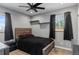Cozy bedroom features a ceiling fan, carpet flooring, two windows with curtains and modern decor at 4102 W Eastman Ave, Denver, CO 80236