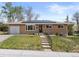 Inviting brick home with solar panels, features an attached garage, and cozy front porch seating at 4102 W Eastman Ave, Denver, CO 80236