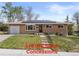 Charming brick home with a well-manicured lawn and solar panels installed on the roof at 4102 W Eastman Ave, Denver, CO 80236