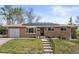 Charming brick ranch-style home featuring a well-manicured lawn, attached garage, and solar panels on the roof at 4102 W Eastman Ave, Denver, CO 80236