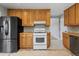 Functional kitchen with wooden cabinets, white stove and black refrigerator at 4102 W Eastman Ave, Denver, CO 80236