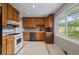 Functional kitchen with wooden cabinets, white appliances, and ample countertop space at 4102 W Eastman Ave, Denver, CO 80236