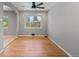 Bright living room featuring a ceiling fan, large window, and beautiful hardwood flooring at 4102 W Eastman Ave, Denver, CO 80236