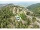 Stunning aerial view of a home nestled among lush, green trees with a beautiful landscape at 16861 Wrangler Trl, Littleton, CO 80127