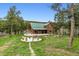 Beautiful log home with a green roof surrounded by a lovely fire pit area at 16861 Wrangler Trl, Littleton, CO 80127