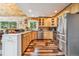 Charming kitchen featuring wood cabinets, stainless steel appliances, and plenty of counter space at 16861 Wrangler Trl, Littleton, CO 80127