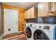 Functional laundry room with modern appliances, storage cabinets, and wood accents at 16861 Wrangler Trl, Littleton, CO 80127