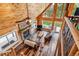 Spacious living room featuring a stone fireplace, wood ceilings, and large windows with a view at 16861 Wrangler Trl, Littleton, CO 80127