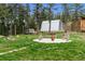 Outdoor space with benches and firepit, storage areas, and mature trees at 16861 Wrangler Trl, Littleton, CO 80127