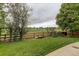 Grassy backyard featuring wood fence, bridge and greenbelt with a park in the distance at 15372 E 117Th Ave, Commerce City, CO 80022